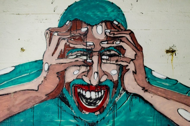 Un graffiti illustrant un homme en train d'hurler en se tenant les mains