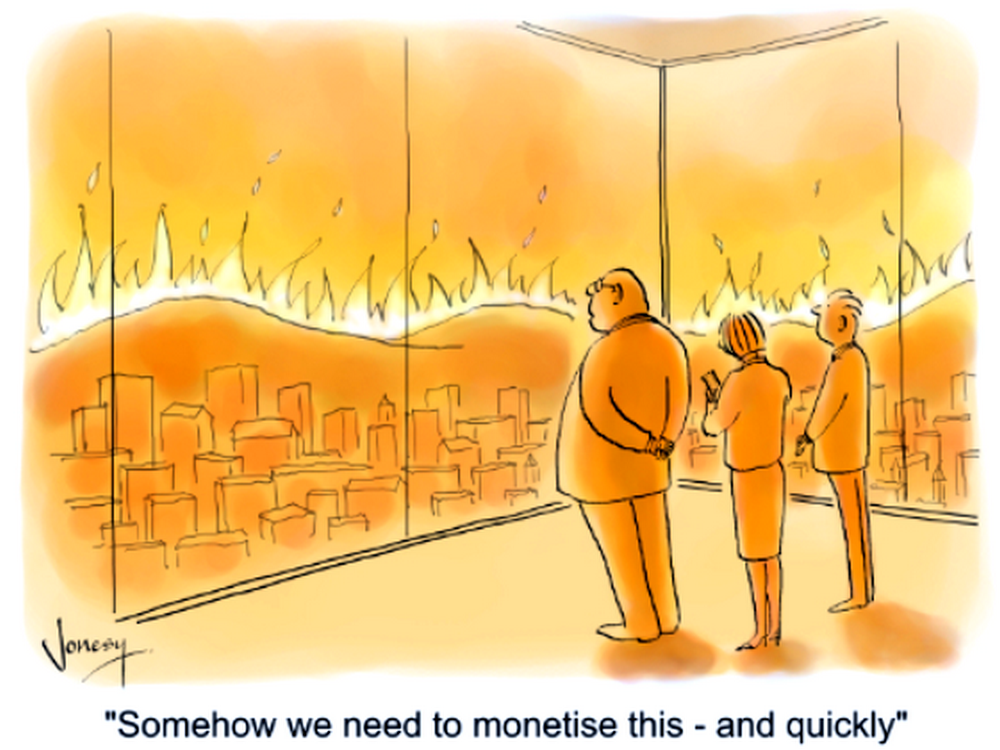 Dessin humoristique montrant trois personnes en costume, debout dans un bureau moderne avec de grandes baies vitrées. À travers les vitres, on aperçoit une ville entière ravagée par un immense incendie, avec des flammes orange qui s'élèvent à l'horizon. Malgré le chaos visible, les personnages semblent détachés et l'un d'eux déclare : « Somehow we need to monetise this - and quickly » (« Il faut qu'on trouve un moyen de monétiser ça - et vite »). Le dessin est signé « Jonesy » en bas à gauche.