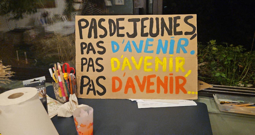 Panneau en carton c'est écrit en majuscule et en plusieurs couleurs : Pas de jeunes, Pas d'avenir.  Pas d'avenir, Pas d'avenir...