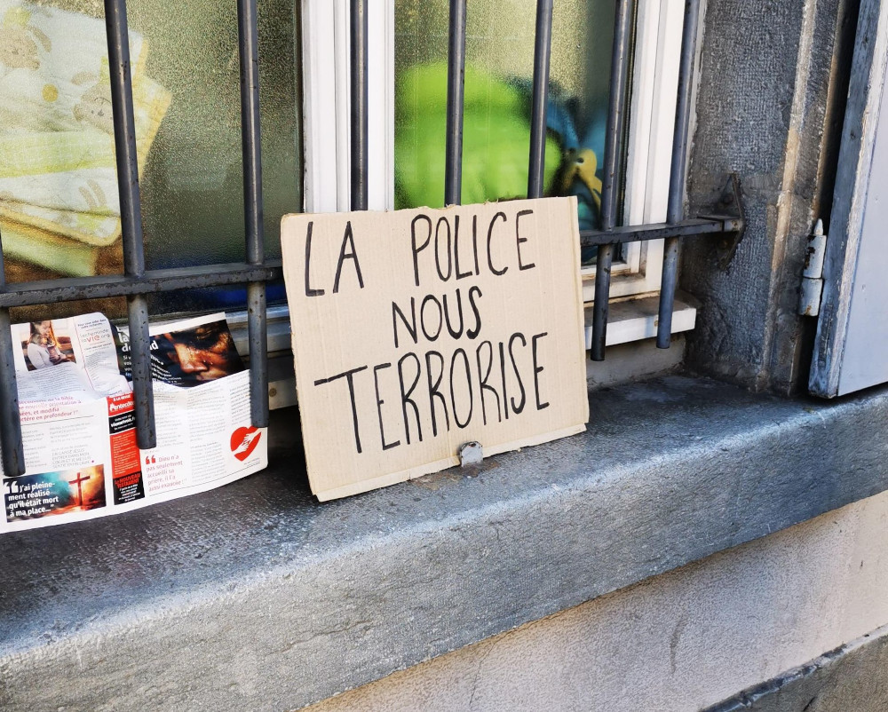 Une pancarte qui dit "la police nous terrorise"
